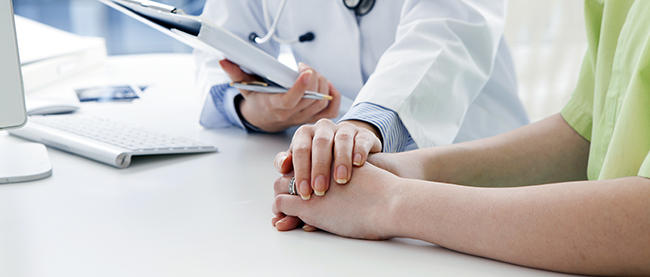 Atención personalizada: doctora dándole la mano a paciente.
